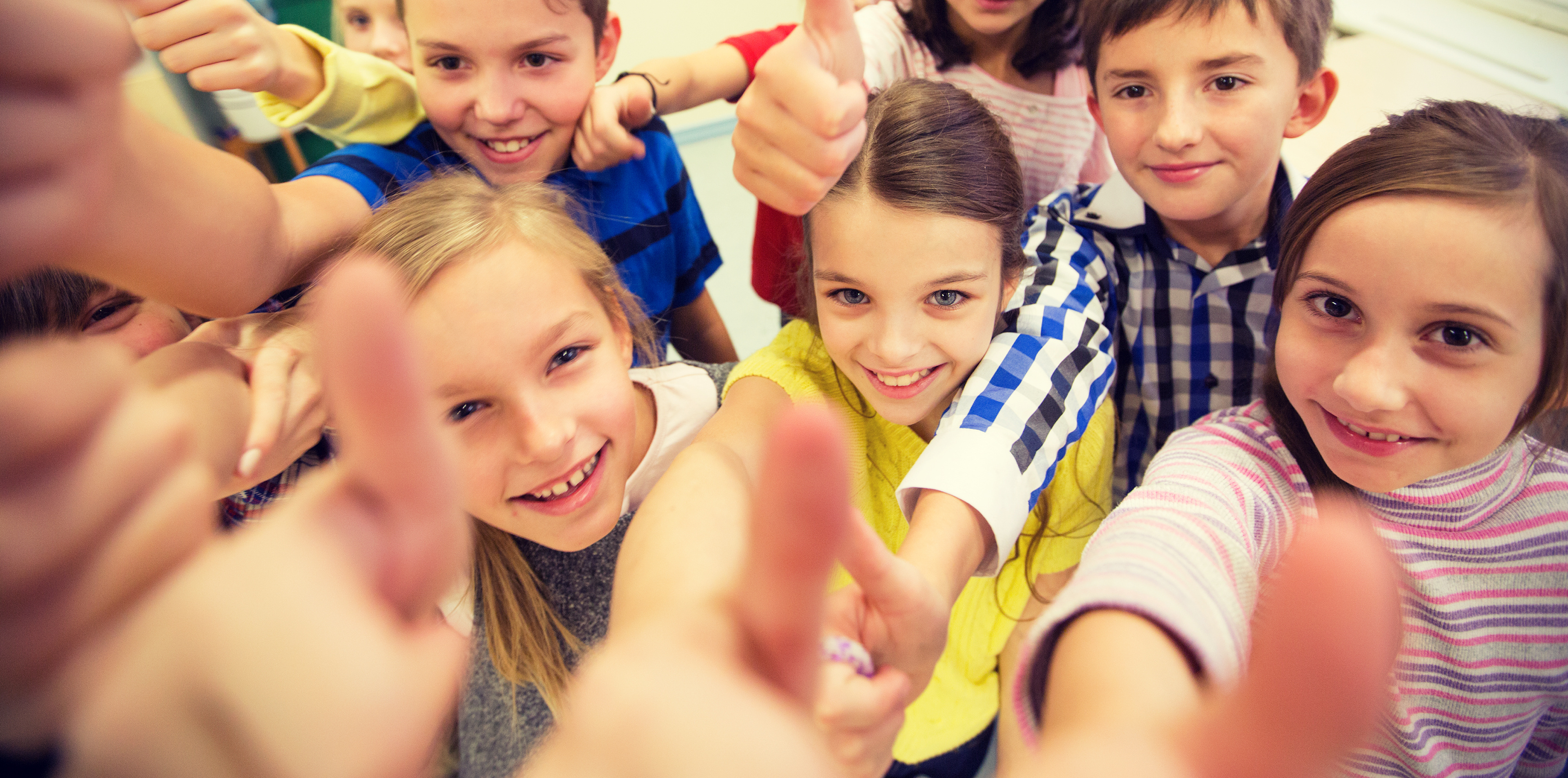 Group of young kids giving thumbs up