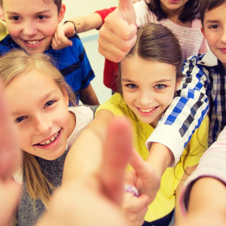  Group of young kids giving thumbs up